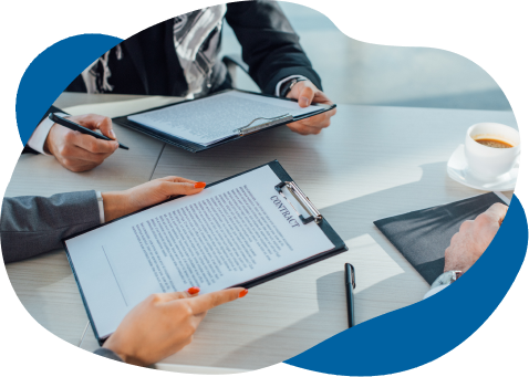 Three professionals discussing a contract at a modern office table, with documents and a coffee cup visible. focus on hands and documents.